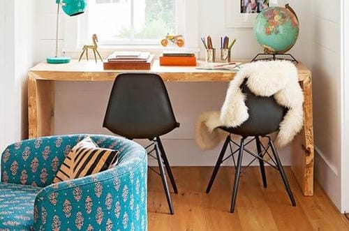 A stylish tidy homework corner features a rustic wooden desk, decorative globe, stationery containers and comfortable seating, creating a cozy dedicated learning space ready for use.